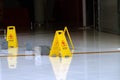 Yellow caution wet floor signs stand next to buckets on the tiled floor Royalty Free Stock Photo